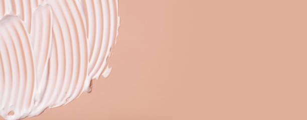 istock Close-up cream moisturiser smear smudge wavy texture on colored background with copy space horizontal format. Skin care beauty product 1411031447
