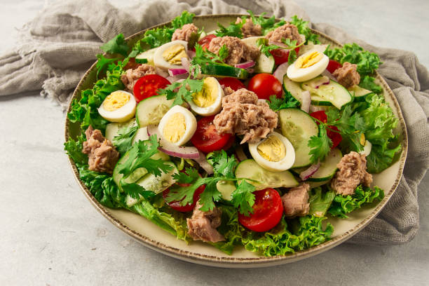 istock Tuna salad, vegetable salad with quail eggs, lettuce, red onion and cucumbers, on a light gray table, keto food, lifestyle, healthy eating, selective focus, top view, no people, 1411034883
