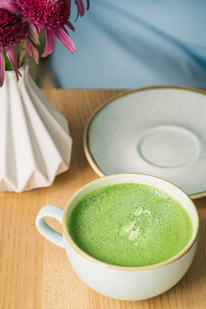 istock Close-up, a large ceramic cup with a green matcha drink on a wooden table. 1411034893