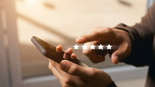 A male customer gives a five-star rating on their smartphone, satisfaction, customer service experience. Service Rating Reviews and Satisfaction Survey Concept. A male customer gives a five-star rating on their smartphone, satisfaction, customer service experience. Service Rating Reviews and Satisfaction Survey Concept. adulation stock pictures, royalty-free photos & images