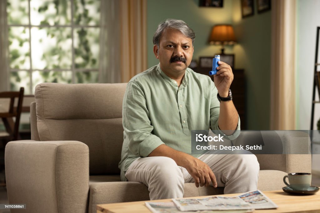 Mature man showing asthma pump, stock photo Mature man showing asthma pump Asthma Inhaler Stock Photo