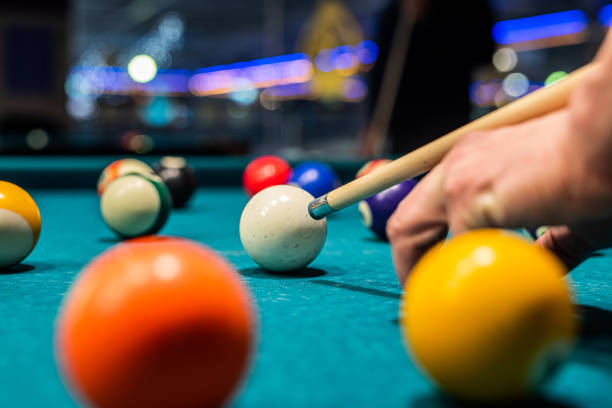 istock Billiard balls on the pool table with player's hands and stick. 1411039434