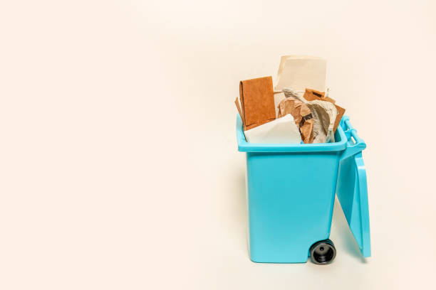 istock Over full paper trash can on white background with copy space 1411039458