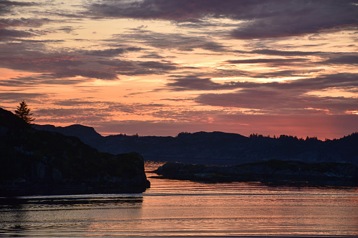 Beautiful colorful pink sunset over a Norwegian sea and archipelago by summer