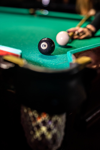 Billiard balls on the table and the player's hands are preparing to strike in the start mode. Indoor sports concept