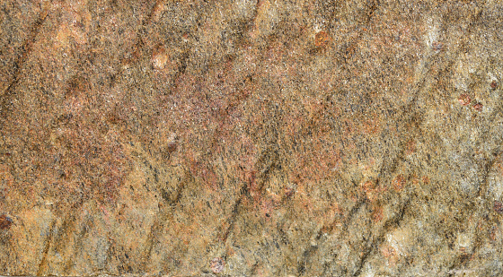 The rough stone surface is naturally colored in tan color and has a streaky background.