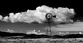 istock Windmill on Hillside in Countryside Rural America with Sky and Clouds Black and White 1411043028