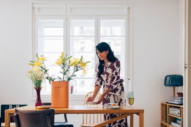 istock A Happy Elegant Woman Standing And Preparing Table For Lunch Before Guests Come 1411043444