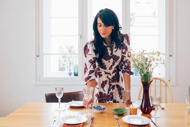 istock A Happy Elegant Woman Standing And Preparing Table For Lunch Before Guests Come 1411043453