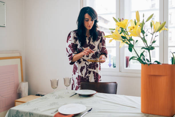 istock A Happy Elegant Woman Standing And Preparing Table For Lunch Before Guests Come 1411043469