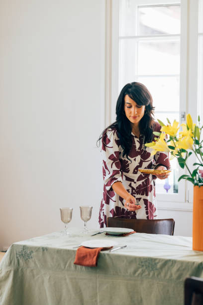 istock A Happy Elegant Woman Standing And Preparing Table For Lunch Before Guests Come 1411043470