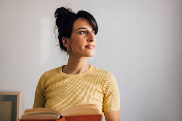 A smiling Caucasian student looking away while learning.