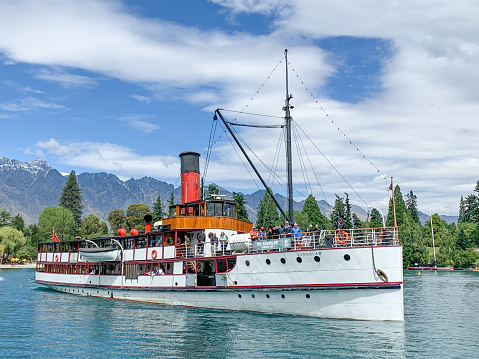 Tourists are enjoying the lake view by tourboat at the Main Town Pier of Queenstown New Zealand, South Island.