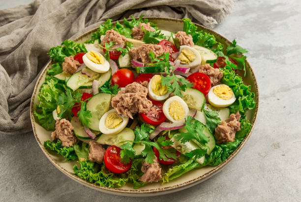 istock Tuna salad, vegetable salad with quail eggs, lettuce, red onion and cucumbers, on a light gray table, keto food, lifestyle, healthy eating, selective focus, top view, no people, 1411043582