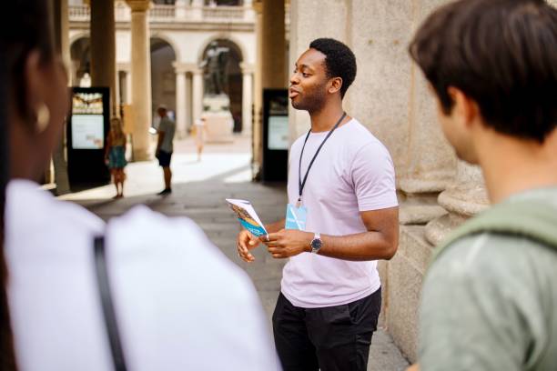 tour guide holding guidebook and talks about famous city sights - city life audio imagens e fotografias de stock