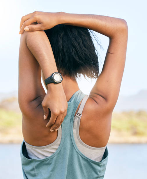 istock One active woman from the back stretching arms and triceps by pulling elbow towards spine while exercising outdoors. Female athlete doing warmup to prepare body and muscles for training workout 1411046572