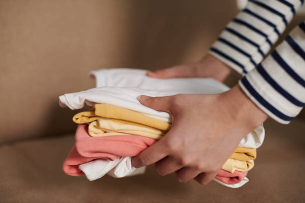 istock Woman Putting Tidy T-shirts on Sofa 1411046767