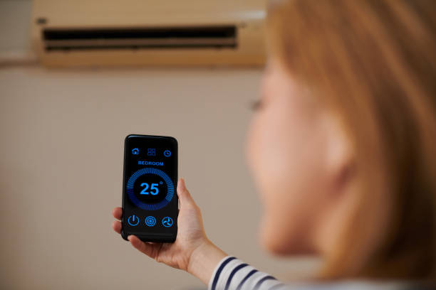 istock Woman Controlling Air Conditioner in Bathroom 1411046799