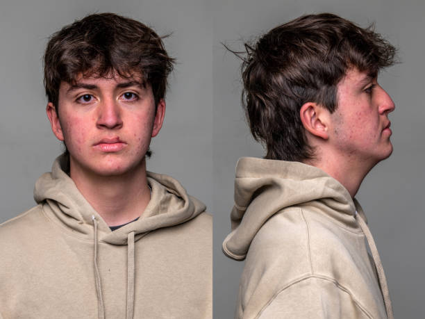 serious teenage boy front and profile mugshots on gray background - achterdocht fotos stockfoto's en -beelden