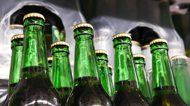 Close-up of many beautiful green glass bottles of beer on a store shelf stock photo