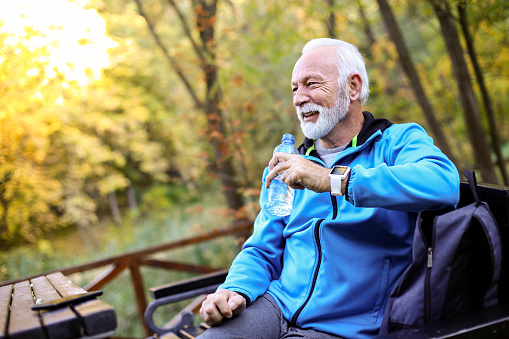Senior man hiking in an autumn park. About 65 years old, Caucasian male.