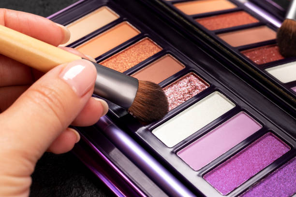 istock Eye shadow palette and female hand with brush closeup 1411050210