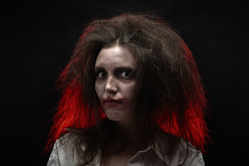 fun crazy young woman with fluffy hair on black background make shy grimace