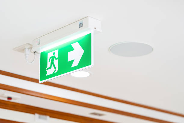 istock A Arrow light box sign of EMERGENCY FIRE EXIT is hung on the ceiling in hospital walkway, Idea for event fire or evacuation drills. 1411054055