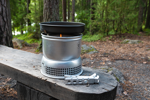 Hameenlinna, Finland. July 10, 2022. Trangia, the portable camping stove on a bench in a forest
