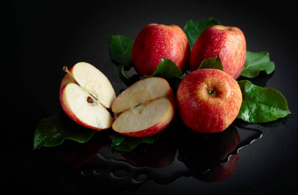 A cross-section of an apple showcasing its seeds, placed on a soft white fabric background