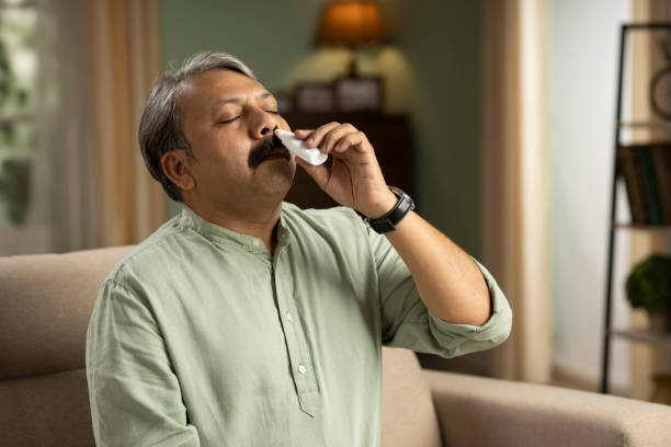 Portrait of senior man with a nasal spray, using nose drops, stock photo stock photo