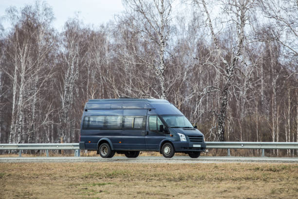 istock minibus moves along country road along birch forest 1411060126
