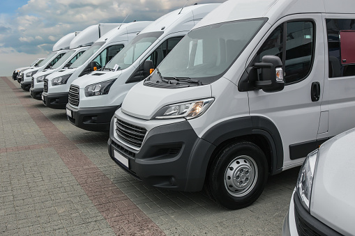 number of new white minibuses and vans outside