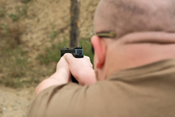 istock a man threatens with a combat pistol. man holding a gun in his hands 1411066473