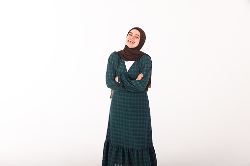 Middle east model going for portrait photos in studio. In this photo she is standing, laughing and looking at camera.