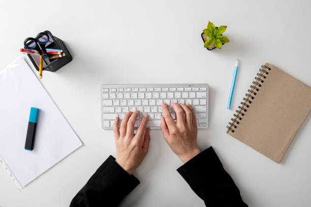istock Female hands on the keyboard on a white table. Top view, flat lay 1411068144