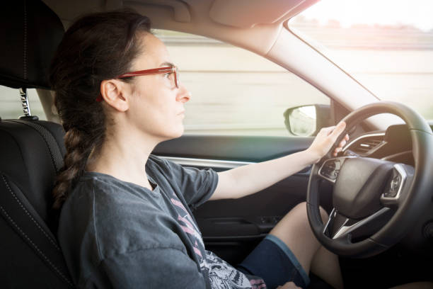 istock Young woman driving car 1411068589