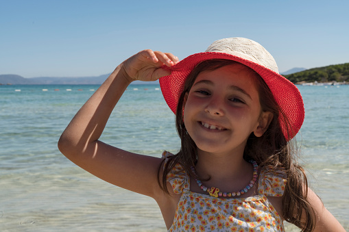 Close up portrait of young little girl in the beach smiling