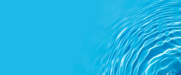 istock Bursts on blue water under sunlight. Top view, flat lay. Banner 1411069942