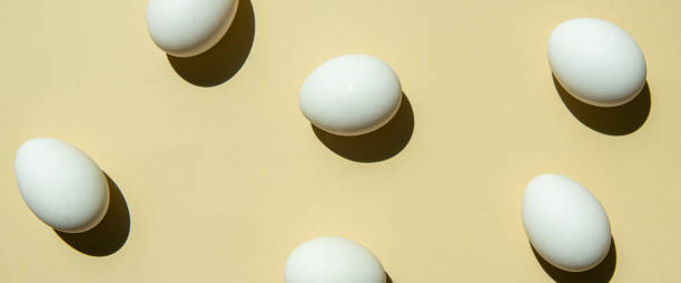 istock Chicken white eggs on a light sandy background. Top view, flat lay. Banner 1411070144