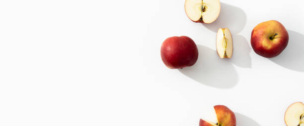 istock Whole, halves and cut apples on a white background. Top view, flat lay. Banner 1411070995