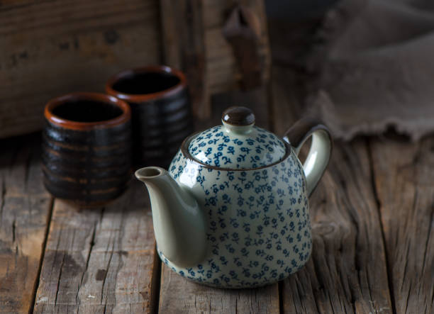 istock Home interior coffee table with tea cups and tea pot or kettle isolated on wooden table side view of morning drink 1411071174