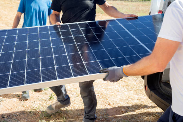 Workers charging solar panels. Alternative energy concept stock photo