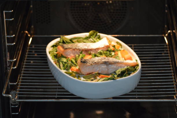 Baked salmon on top of a variety of vegetables in cream