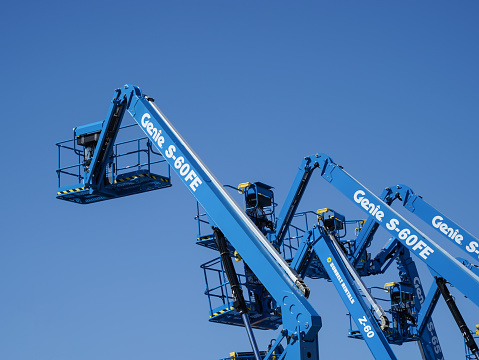 Group of aerial work platforms for construction and material handling. Close-up to the basket for moving people and tool. Extended arms