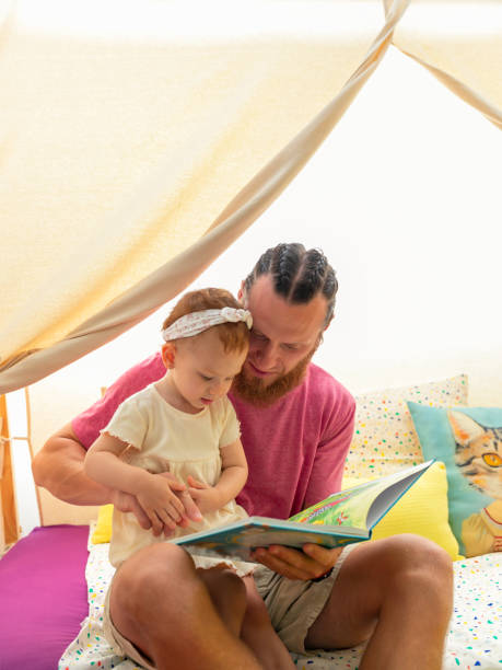 istock father reading a story with his daughter. vertical. 1411075076