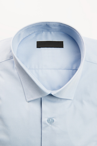Folded blue shirt on white background.