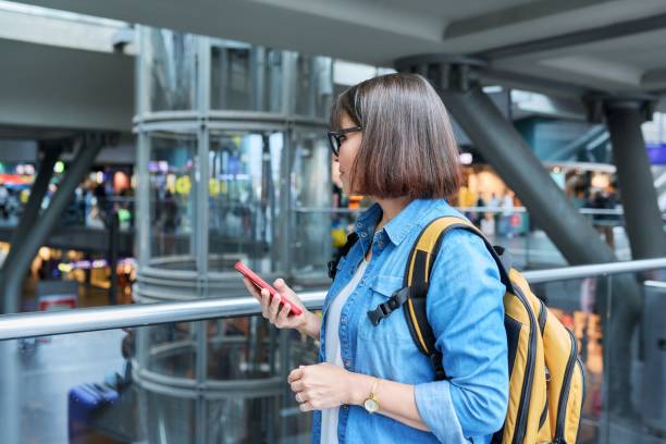 istock Middle-aged woman with a backpack in modern station building 1411076553
