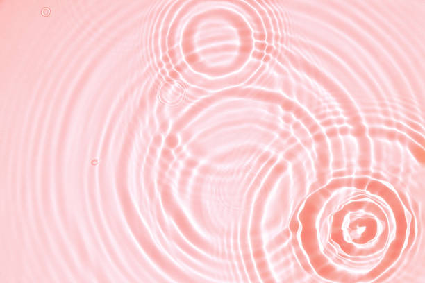istock Pink water texture, cosmetic background pink water surface with rings, ripples 1411078339