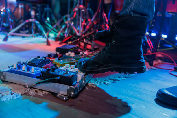 guitarist's foot on the stage effect pedal switches during the concert stock photo